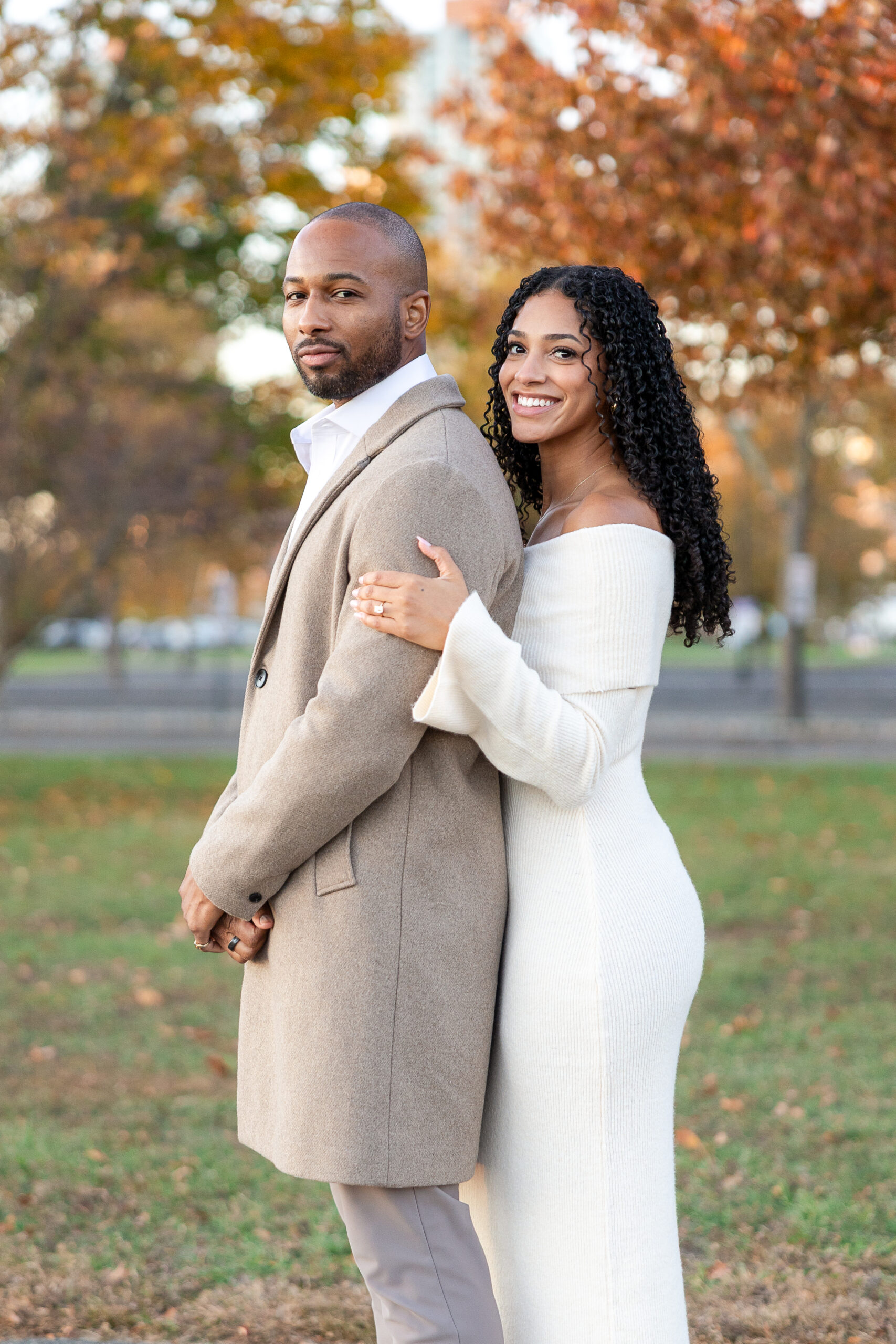 Couple walking hand in hand during engagement session at Liberty State Park in autumn