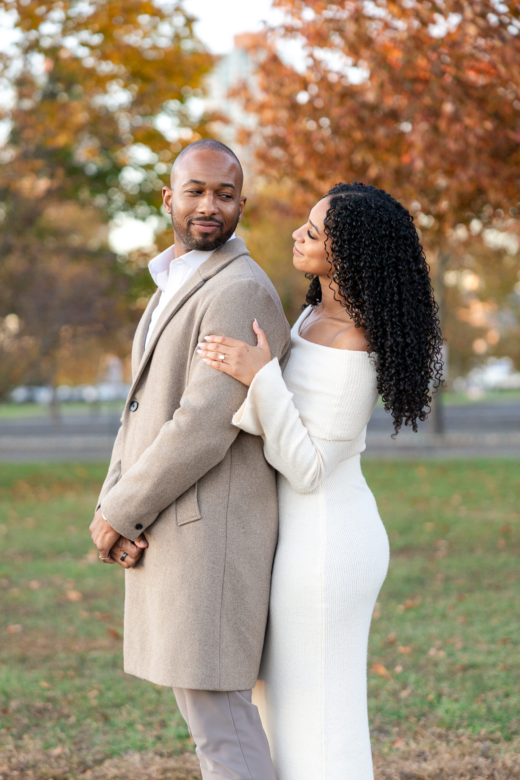 Couple walking hand in hand during engagement session at Liberty State Park in autumn