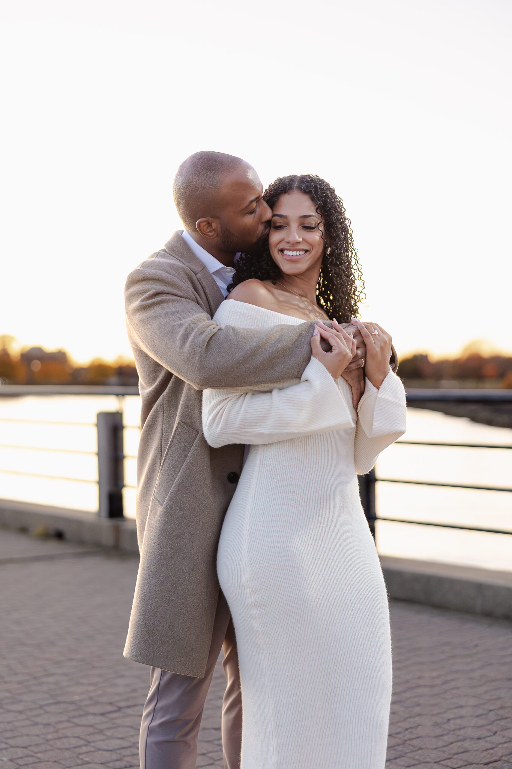 Candid engagement photo in Liberty State Park with NYC skyline at sunset