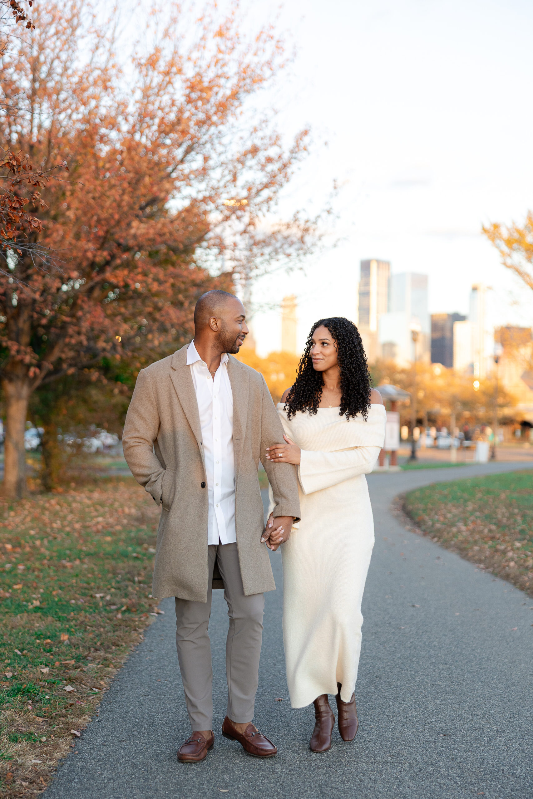 Couple walking hand in hand during engagement session at Liberty State Park in autumn