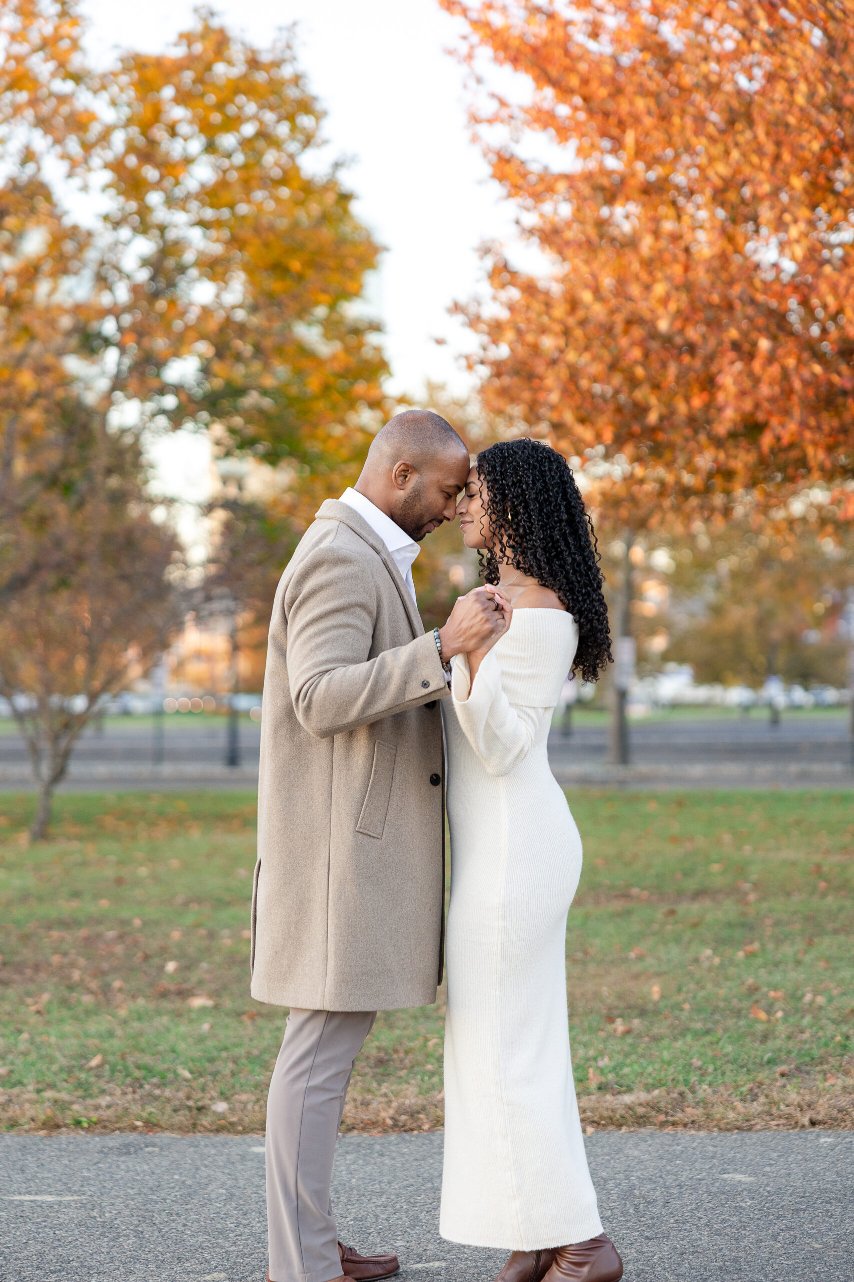 Couple walking hand in hand during engagement session at Liberty State Park in autumn