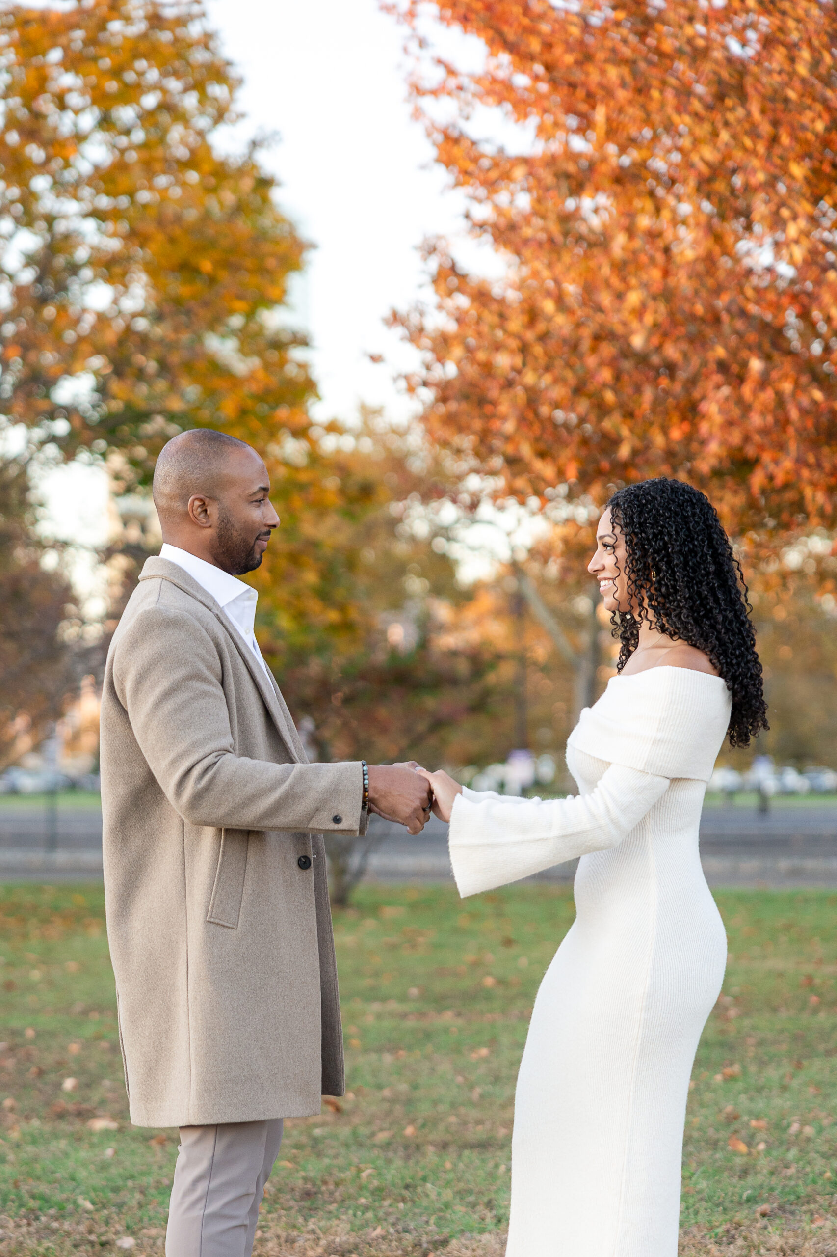 Couple walking hand in hand during engagement session at Liberty State Park in autumn