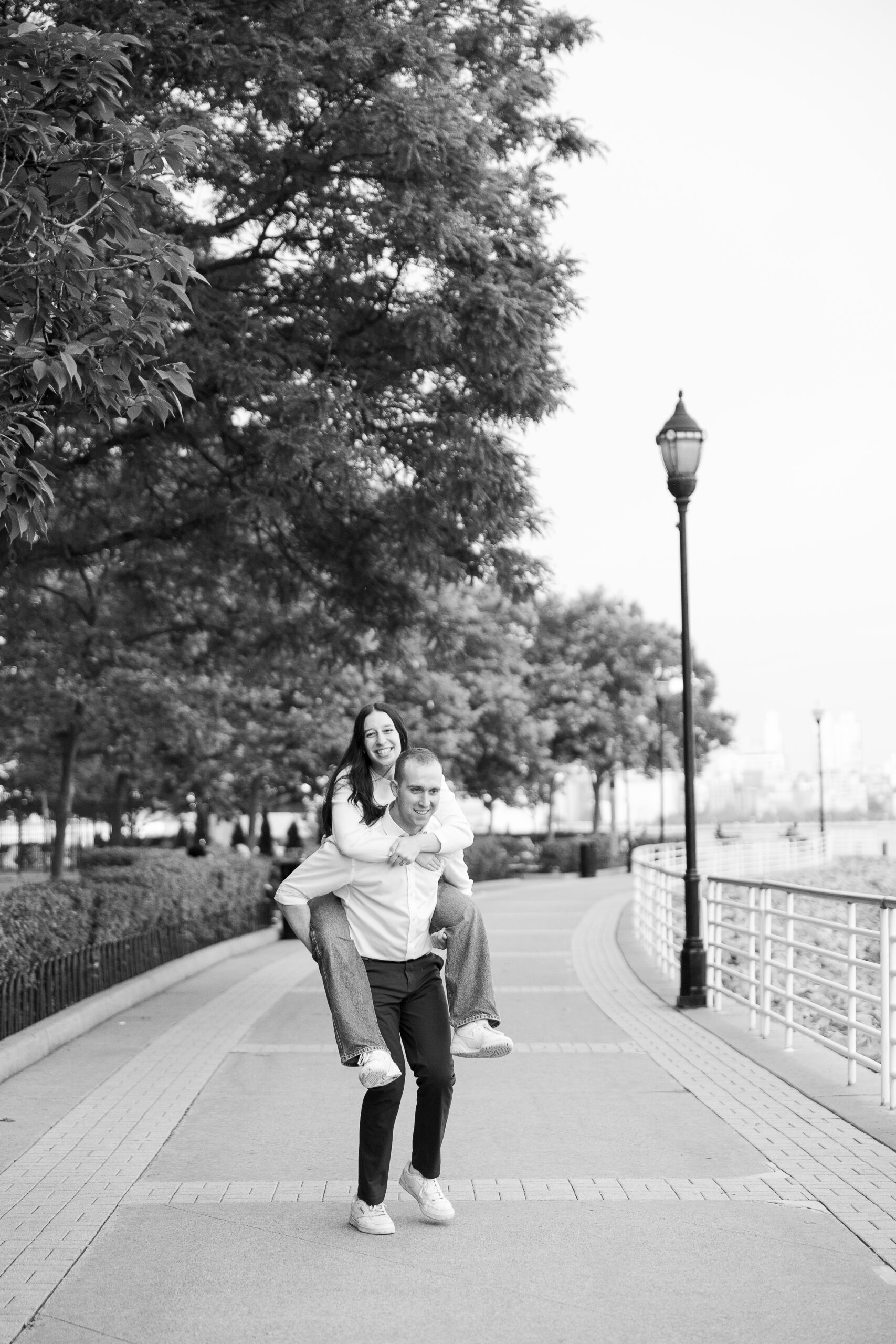Fun piggy ride portraits of couple in Jersey City