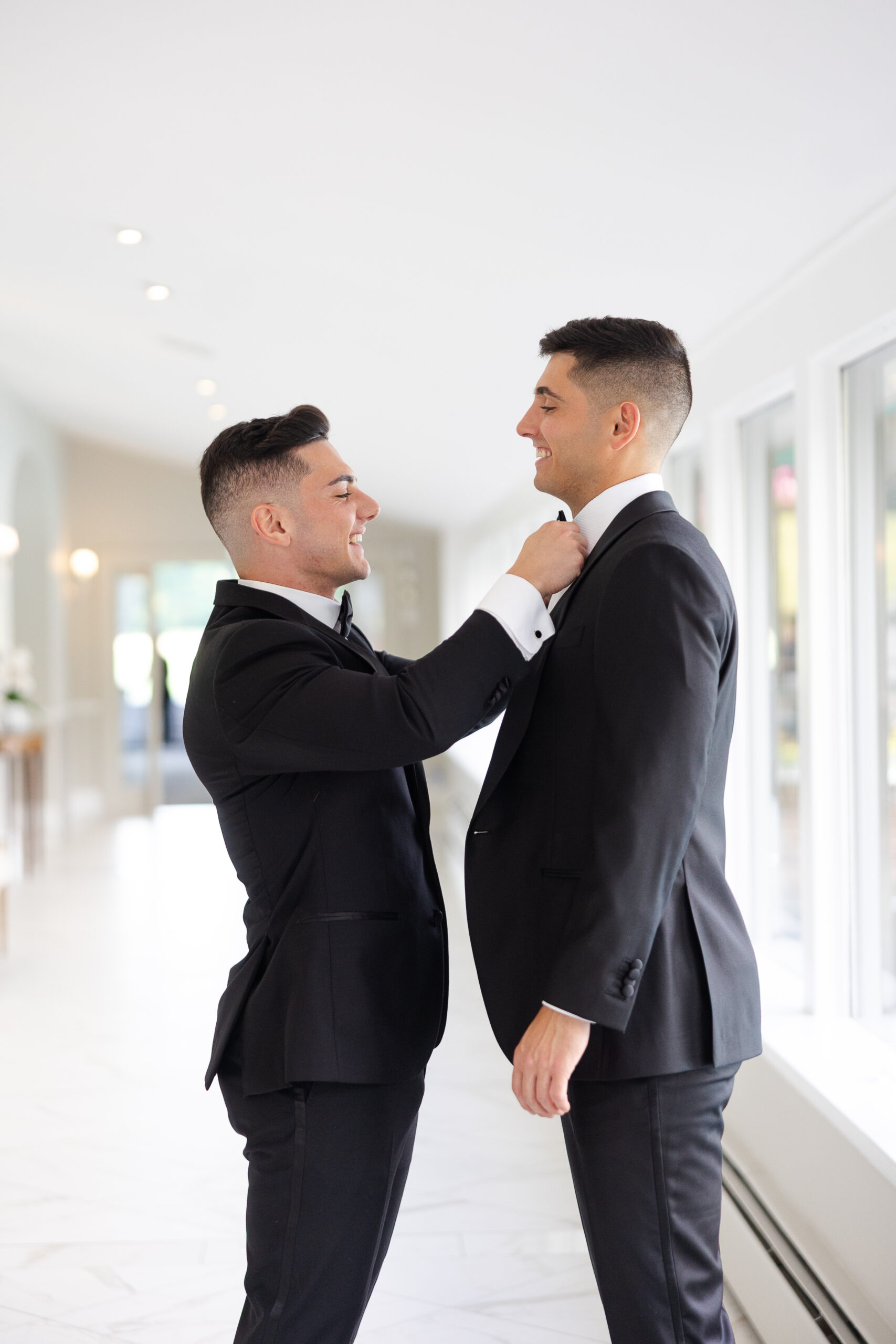 Groom getting dressed with his best man on wedding day