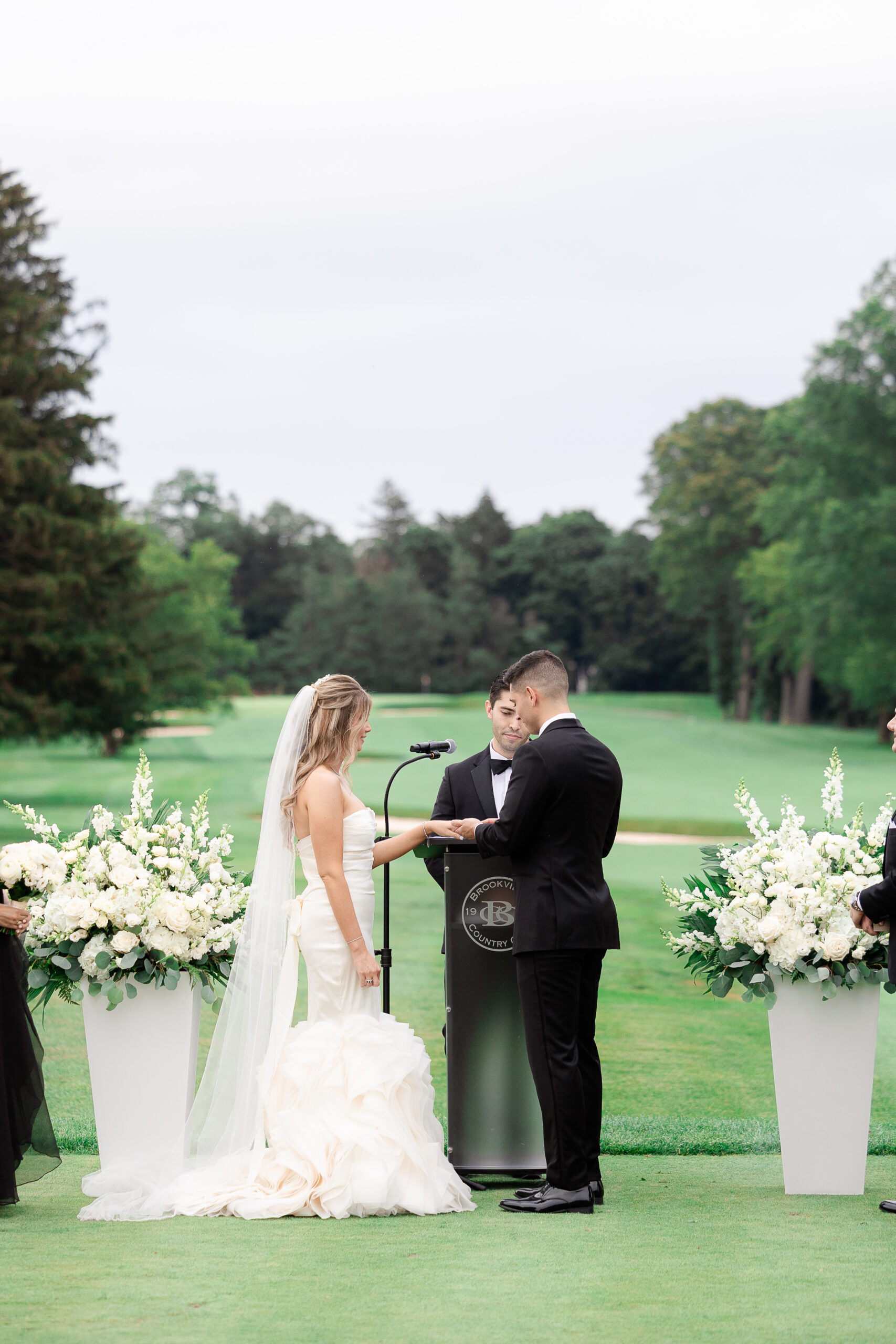 Bride and groom exchanging ring at country club wedding